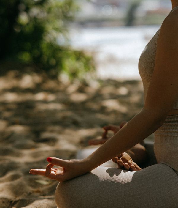 Person meditating peacefully outdoors, embodying well-being and calm.