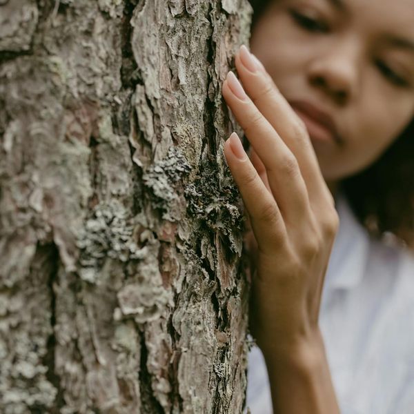 Woman feeling energetic and balanced in a bright, natural environment.